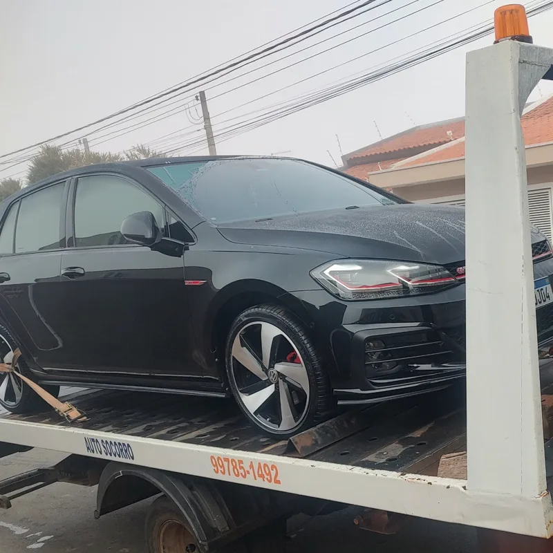 Carro esportivo preto sendo transportado na plataforma da JP Guincho